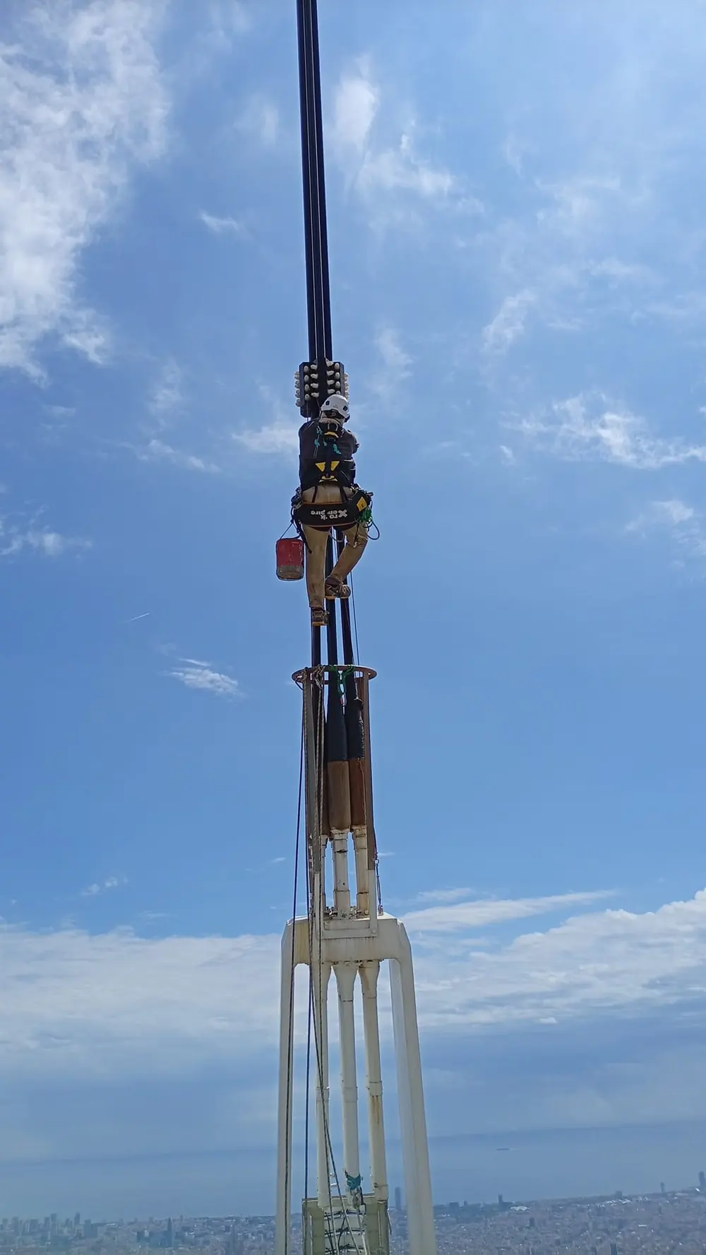 Técnico de Océano Vertical en un mástil de antena sobre la ciudad